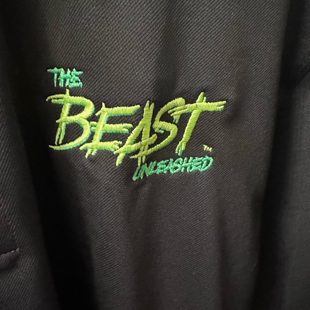 Nike black polo with left arm logo. Front of shirt has BEAST logo
